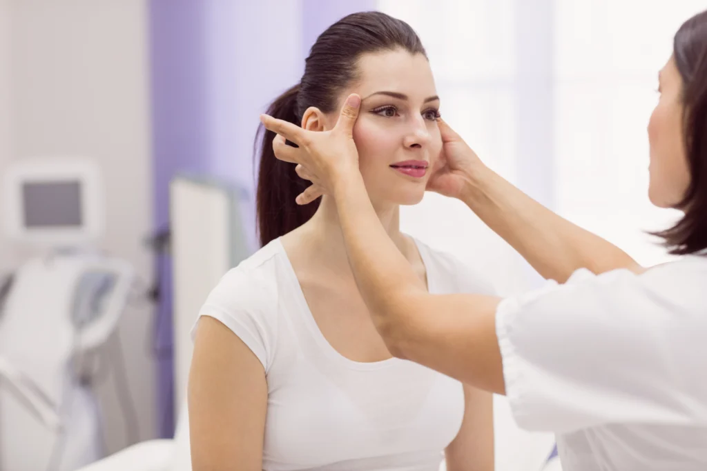 Doctor examining female patient for surgical facelift vs thread lift.