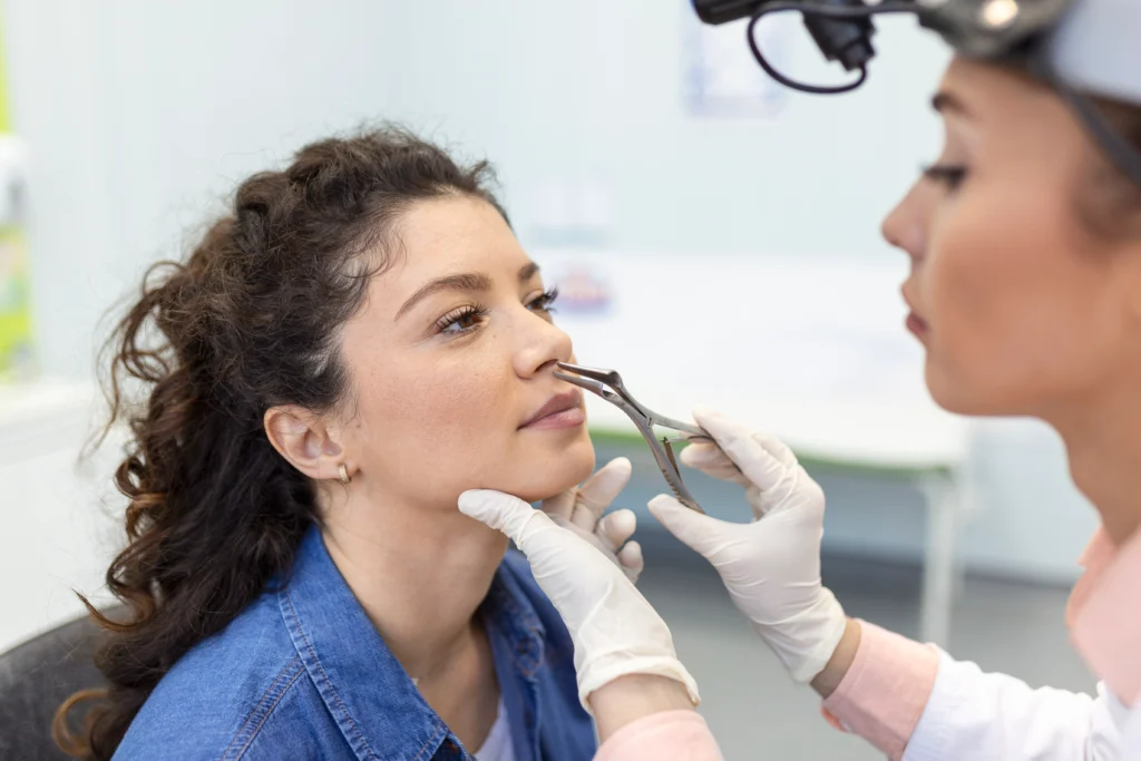 Doctor examining deviated septum of a woman.
