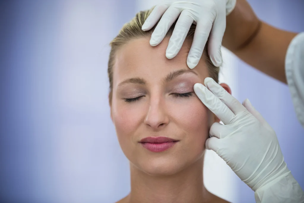 Doctor examining female patient for Blepharoplasty and Brow Lift procedures.